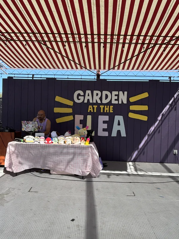 The Garden at the Flea backdrop wall behind the market vendor tables