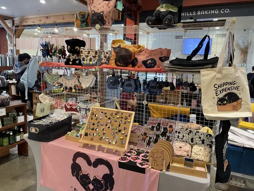 The front of our booth with the Shipping: Expensive tote, denim crossbody pouches, and the pin board