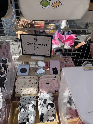Quilted coin pouches, compact mirrors, and black cat print zip pouches on the display shelf