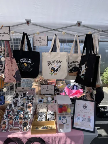 Duckie Is My Best Friend, Nugget Thief, and Shipping: Expensive cat tote bags hanging on the grid wall