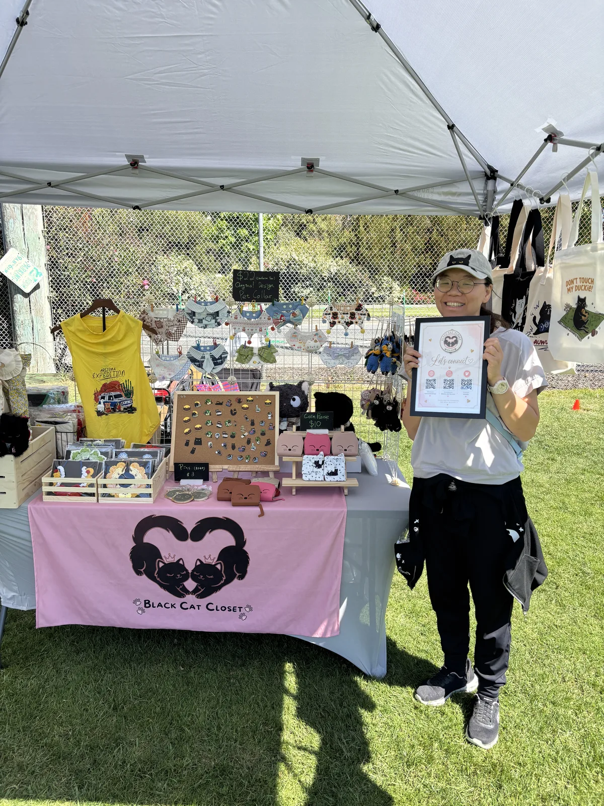 Winnie holding our "Let's connect" sign at the Nyangi Studio USA booth, San Leandro 250th Independence Day Celebration