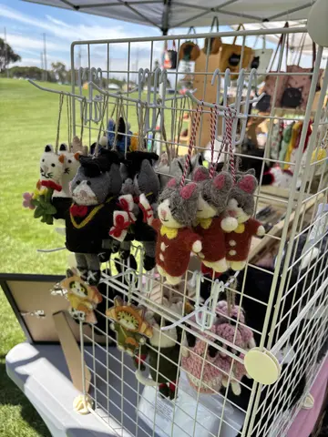 Wool-felt cat ornaments hanging from a wire display rack