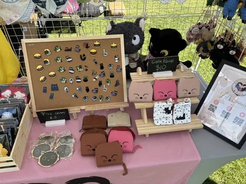 Enamel pin board with cat-shaped coin purses and black cat plush